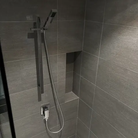 Bathroom with glass enclosure and integrated storage