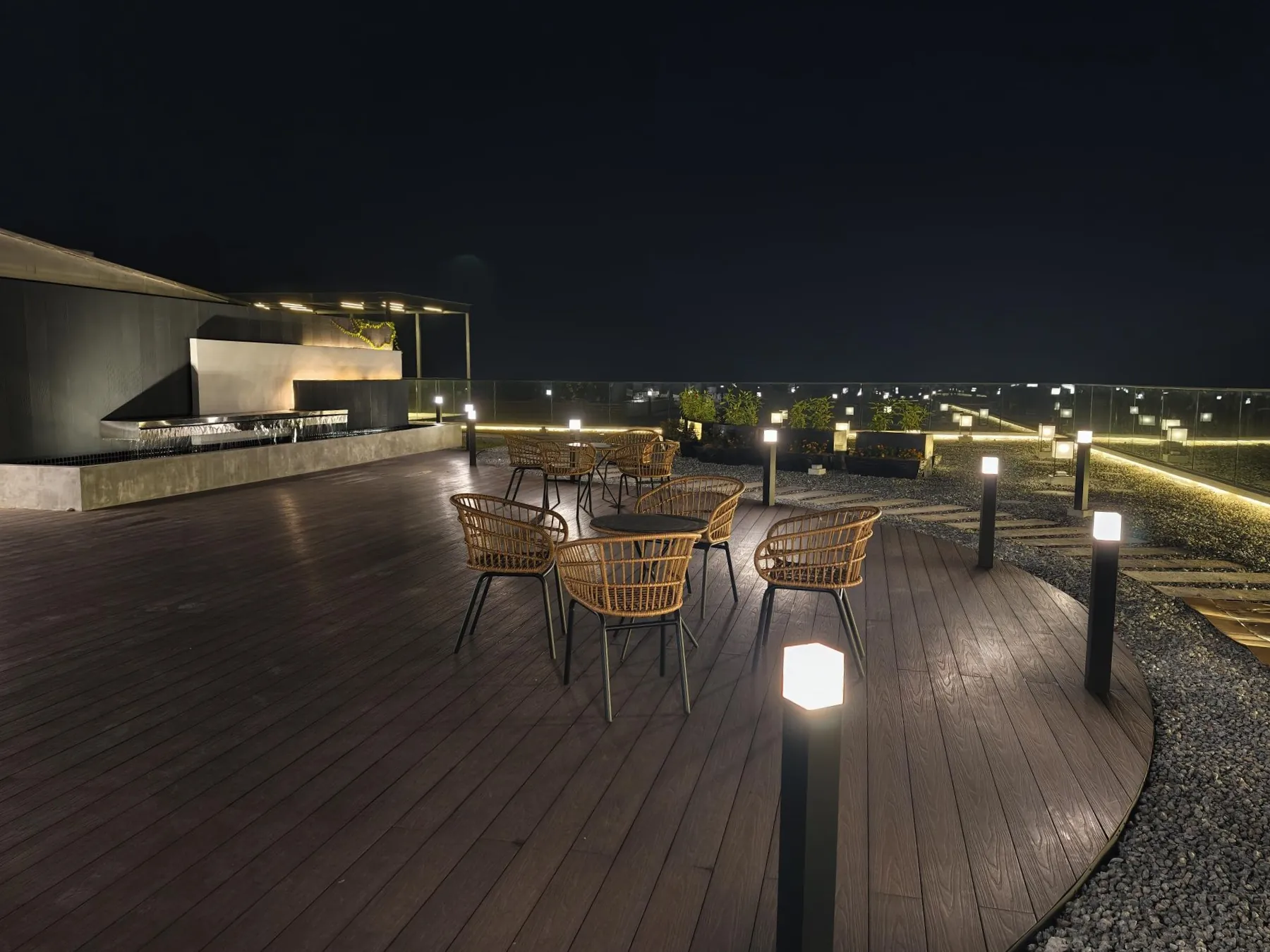 Roof terrace at night, lit bollards along the timber deck