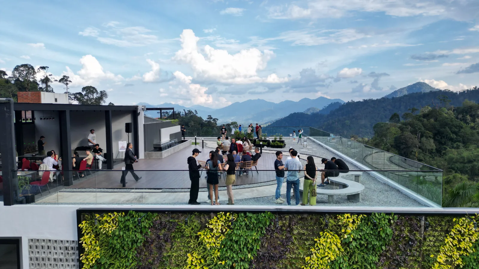 Residents on the roof terrace of Block C, glass balustrade and the Genting hills beyond
